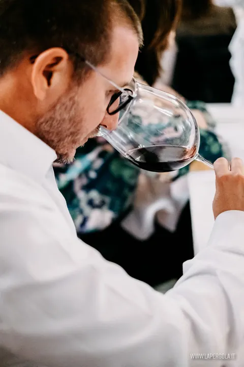 Ospite annusa un calice di vino rosso