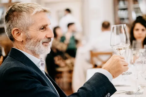 Ospite sorridente con calice di vino