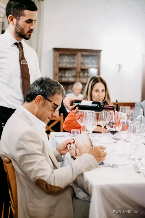 Il sommelier versa il vino agli ospiti